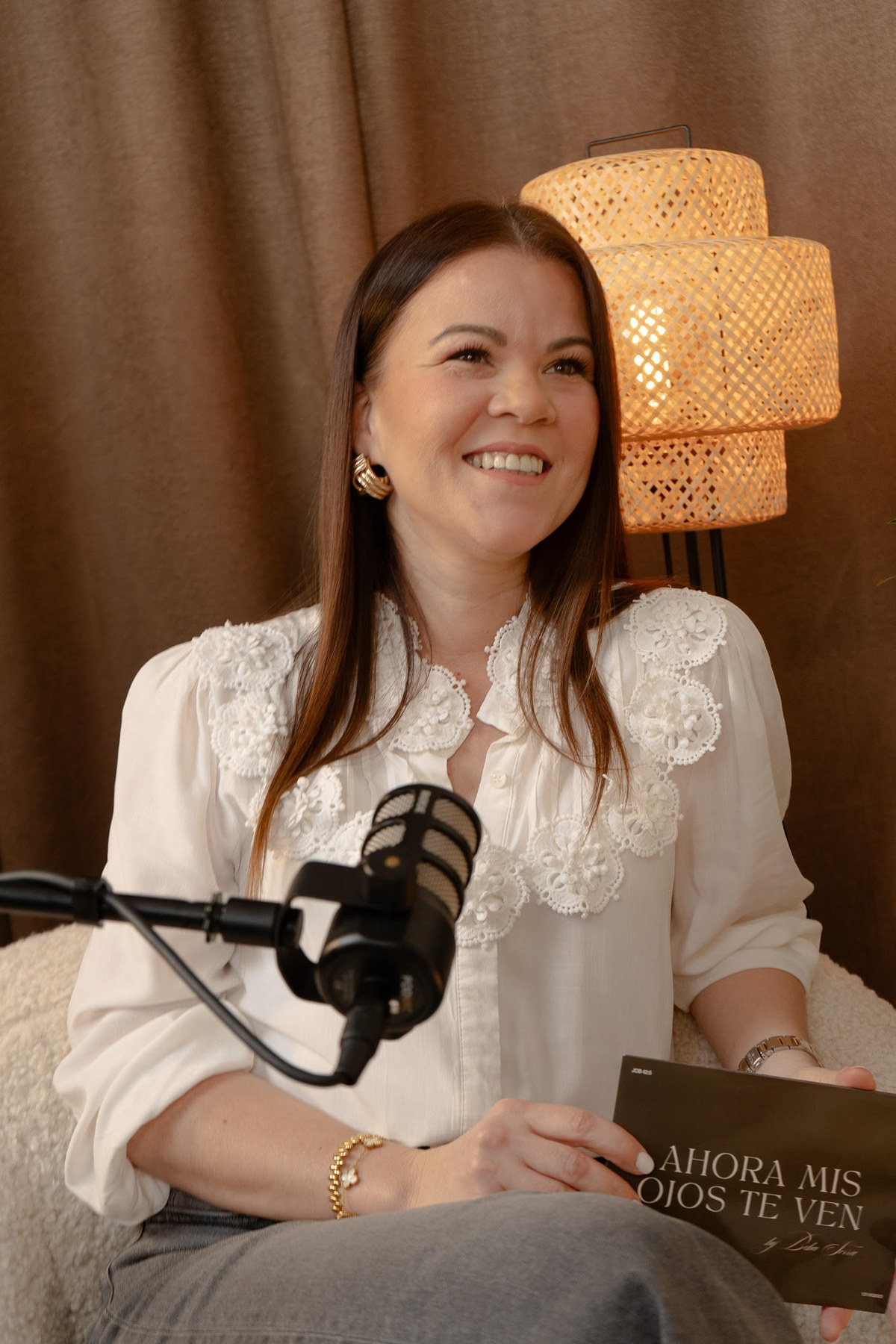Beba Serra sonriendo frente al micrófono, con la tarjeta de Ahora mis ojos te ven